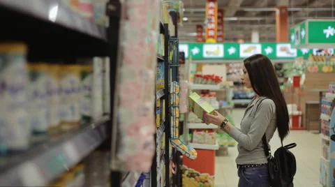 Young pretty girl shopping in a grocery store/supermarket Stock Footage