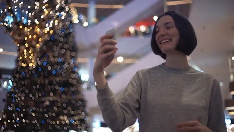 Young pretty girl smiling using a smartphone taking selfie in shopping mall. Stock Footage 83365866