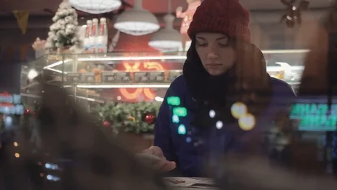 Young pretty girl using smartphone taking photo sitting inside cafe. Xmas time Stock Footage 83080562