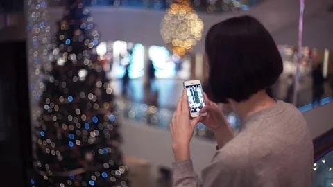Young pretty girl using smartphone taking photo in shopping mall. Stock Footage 83368091