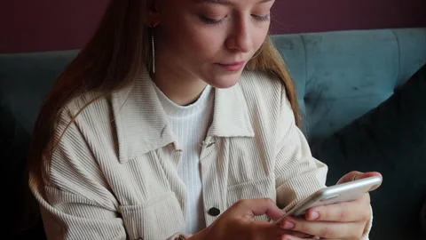 Young pretty girl using smartphone in cafe. Texting message Stock Footage 206442105