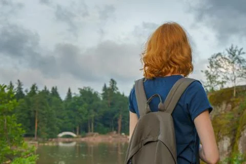 Young pretty lady with backpack walking outdoors in summer evening. Tourist o Stock Photos