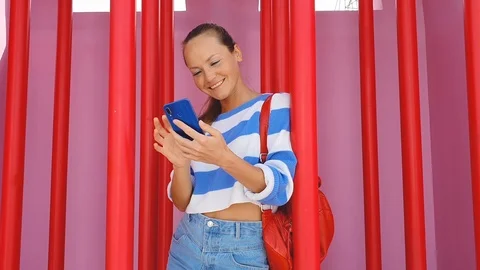 Young pretty lady at the red background holding checking-in her flight on smart Stock Footage 123897563