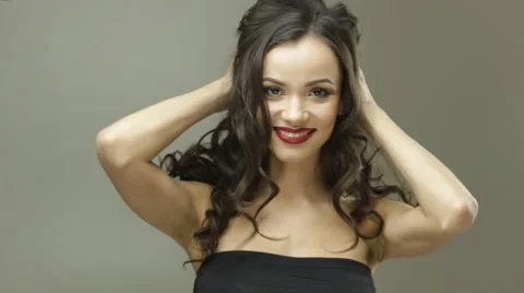 Young pretty lady touching her hair, turning head fast several times and smiling Stock Footage 63095132