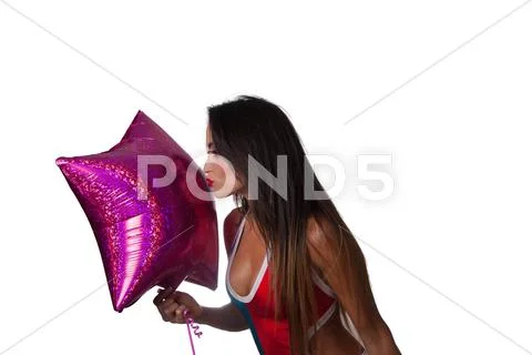 Young pretty latino woman playing with a purple balloon Stock Photos