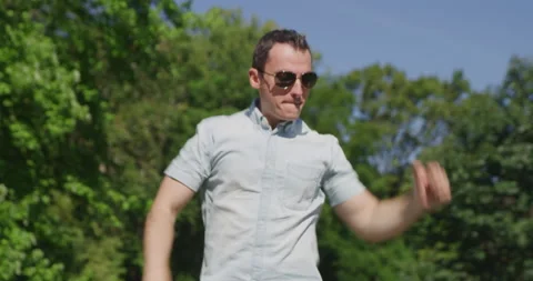 Young pretty man is singing and dancing in summer park 4k Stock-Footage 138326302