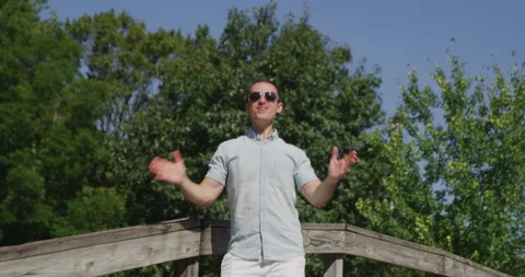 Young pretty man is singing and dancing in summer park 4k Video stock 138326445