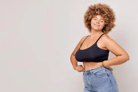 Young pretty plus size or plump woman celebrating her natural body look. Closed Foto stock