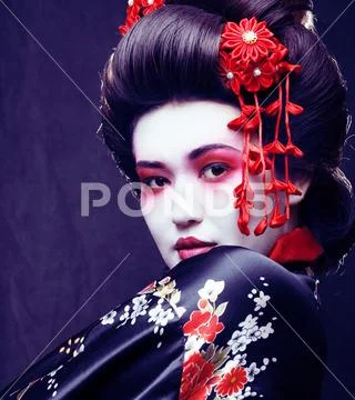 Young pretty real geisha in kimono with sakura and decoration on Stock Photos