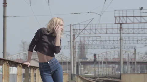 Young pretty shy model walking on the railway and smiling Stock Footage 63632826