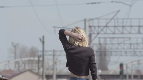 Young pretty shy model walking on the railway and smiling while windy Stock Footage 63638185