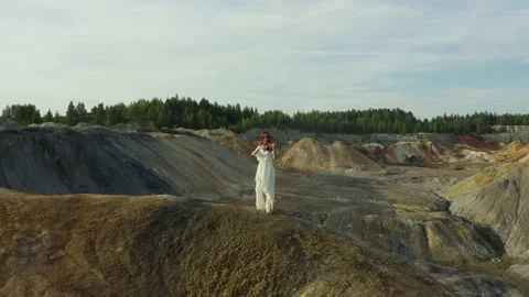 Young pretty slender red-haired woman with long hair in white dress is playing v Stock Footage 221031125