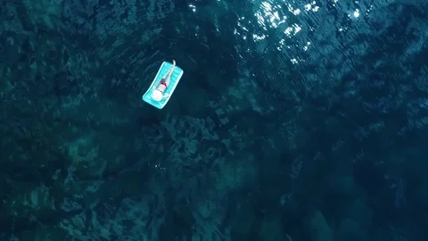 Young pretty woman lying on air mattress on the lake Vidéo 79582453