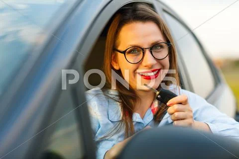 Young pretty woman sitting in a car with the keys in hand Stock Photos