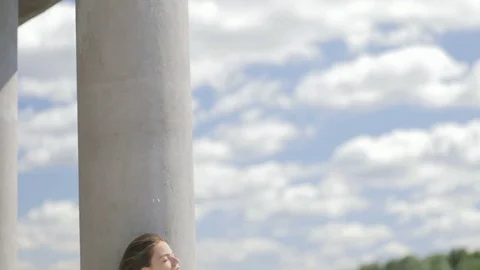Young pretty woman sitting near river with closed eyes Stock Footage