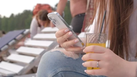 Young pretty woman using smartphone while lying on sunbed on terrace Stock Footage 245347340