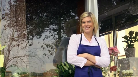 Young pretty woman working as florist in shop and smiling Stock Footage