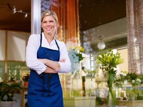 Young pretty woman working as florist in shop and smiling Stock Photos