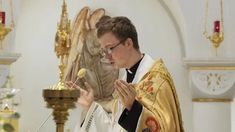 Young priest reads Holy Scriptures at service in the church with his palms up. Stock Footage 169034307