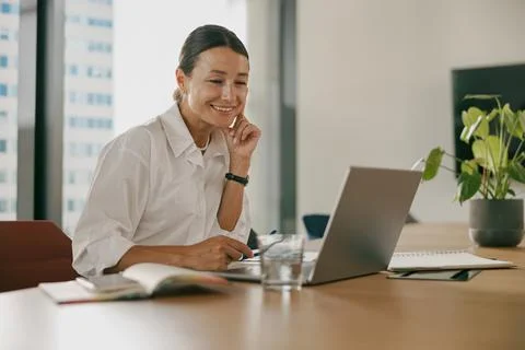 A Young Professional Actively Engaged Working on a Laptop in a Modern Office Stock Photos