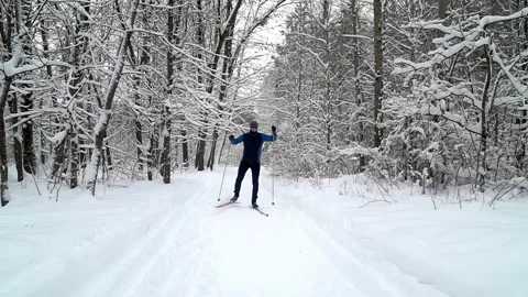 Young professional athlete does cross country skiing along snowy track in a fore Stock Footage 231167223