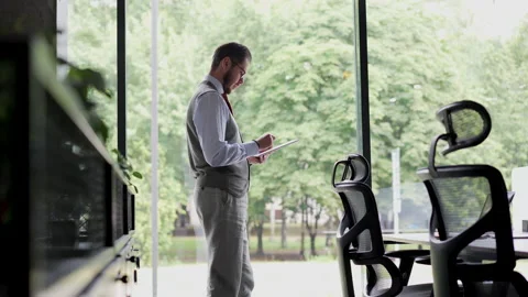 Young professional businessman worker using digital tablet standing in office Stock Footage 218312519