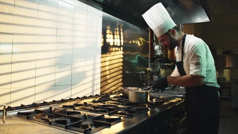 Young professional chef in kitchen while preparing gourmet dishes with a pot Stock Footage 268200603