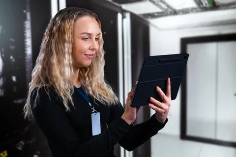 Young professional consultant using a tablet in a modern data center environment 스톡 사진