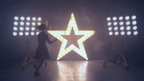 A young professional dancer performs a fast number on stage in the light of the Stock Footage 81711776