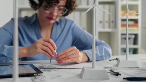 Young professional designing renewable energy models in a bright office work Stock Footage 323717211