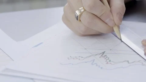 Young professional is drawing on documents sitting in modern office indoors. Video stock 88315977