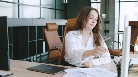 Young professional feeling stressed while working at a modern office desk during Stock Footage 315782763