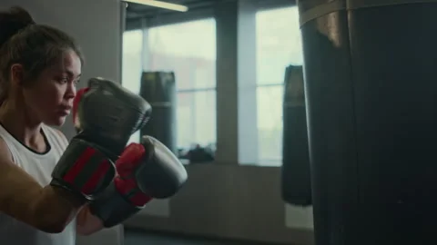 Young Professional Female Boxer Practising on Punch Bag at Gym Stock Footage 277559839