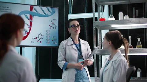 Young professional female lab scientists analyze genetic data and explore Stock Footage 307341132