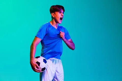 Young professional football player isolated on blue background. Winning game Stock Photos
