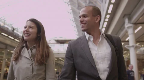 Young professional group chat as they walk through a busy railway station Stock Footage 35147282