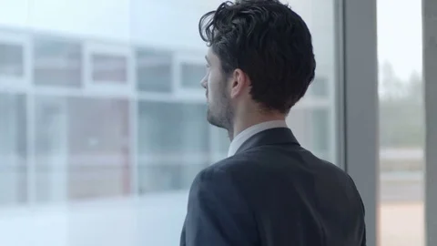 Young professional looking through the window from his workplace Stock Footage 75550281