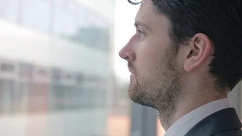Young professional looking through the window from his workplace Stock Footage 75550501