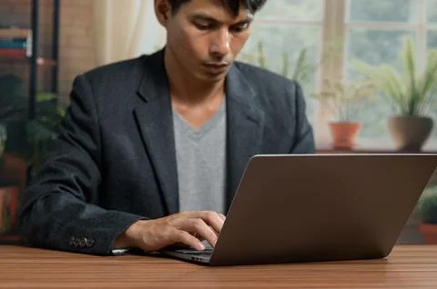 Young Professional Man Using Laptop for Work or Study in Modern Office Stock Photos