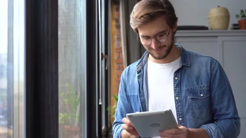Young professional man worker using digital tablet standing at home office Stock Footage 142877555