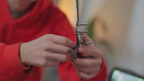 Young professional sitting at desktop at work composing all elements of drone in Stock Footage 186148293