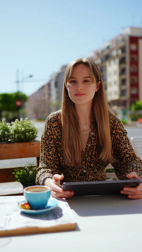 Young professional working remotely, drinking coffee at outdoor cafe, browsing Stock Footage 308341125