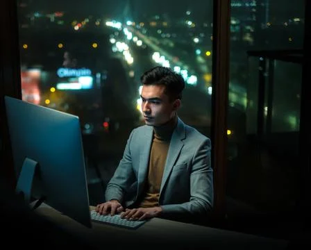 Young Professional Write Report at Night Office Fotos Stock