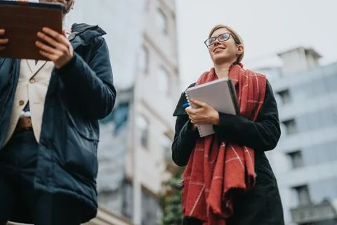 Young professionals collaborating outdoors with technology and documents Stock Photos