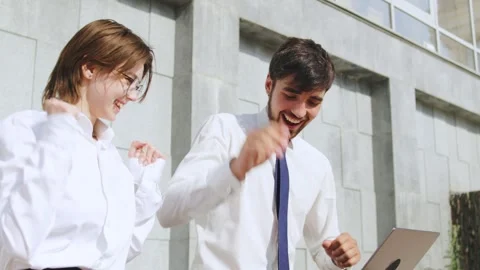 Young professionals engaging in a friendly high-five outside a modern office Stock Footage 316046560