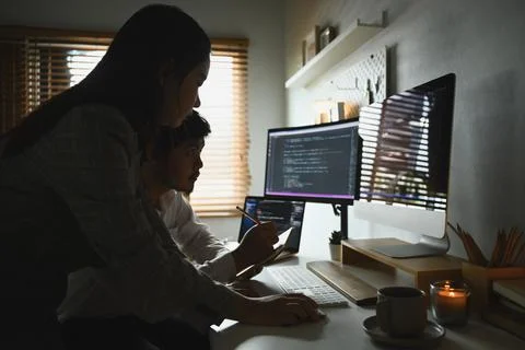 Young professionals team working in software development in dark home office Stock Photos