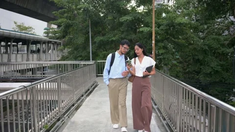Young professionals walking and collaborating on smartphone in bangkok Stock Footage 295557881
