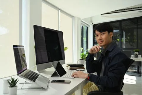 Young professionals web developer sitting in modern corporate office and looking 스톡 사진
