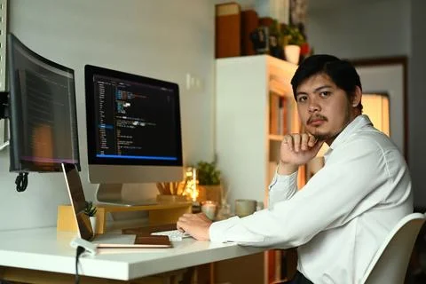 Young professionals web developer writing code on computer monitor at Stock Photos