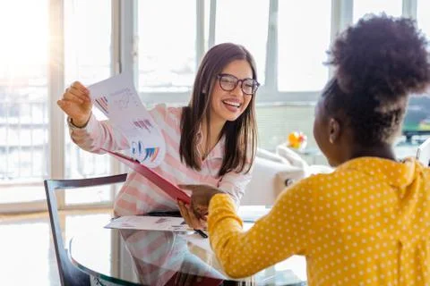 Young professionals work in company, using laptop and tablet. Two women are a Stock Photos